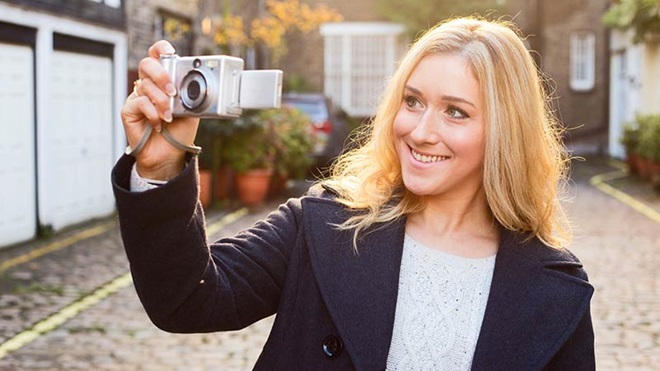 vrouw trekt foto met compactcamera