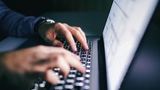 Vingers schrijven op een computertoetsenbord.